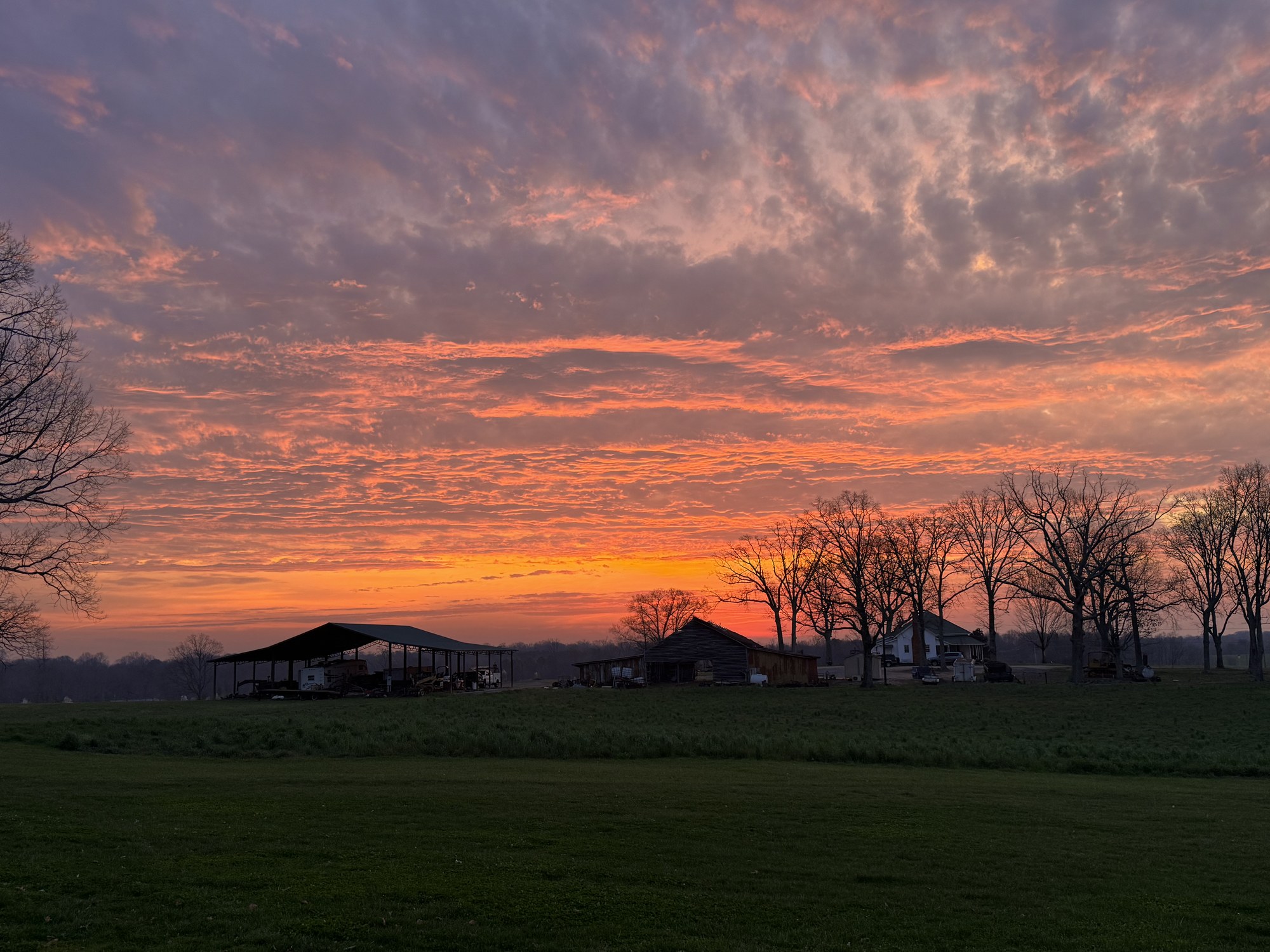 Dramatic sunrise over the farm pavilion and old wooden barn