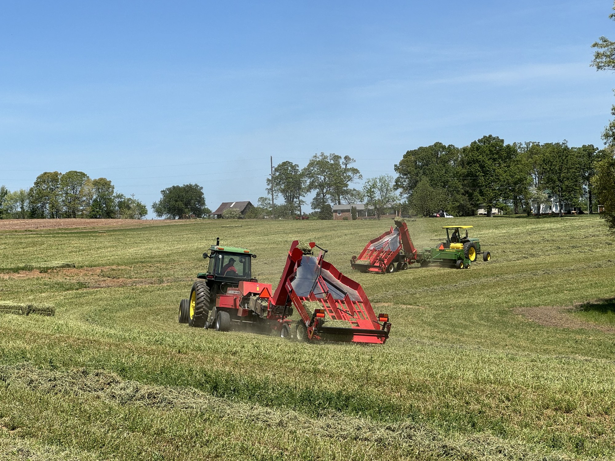 Two tractors working a hay field at harvest